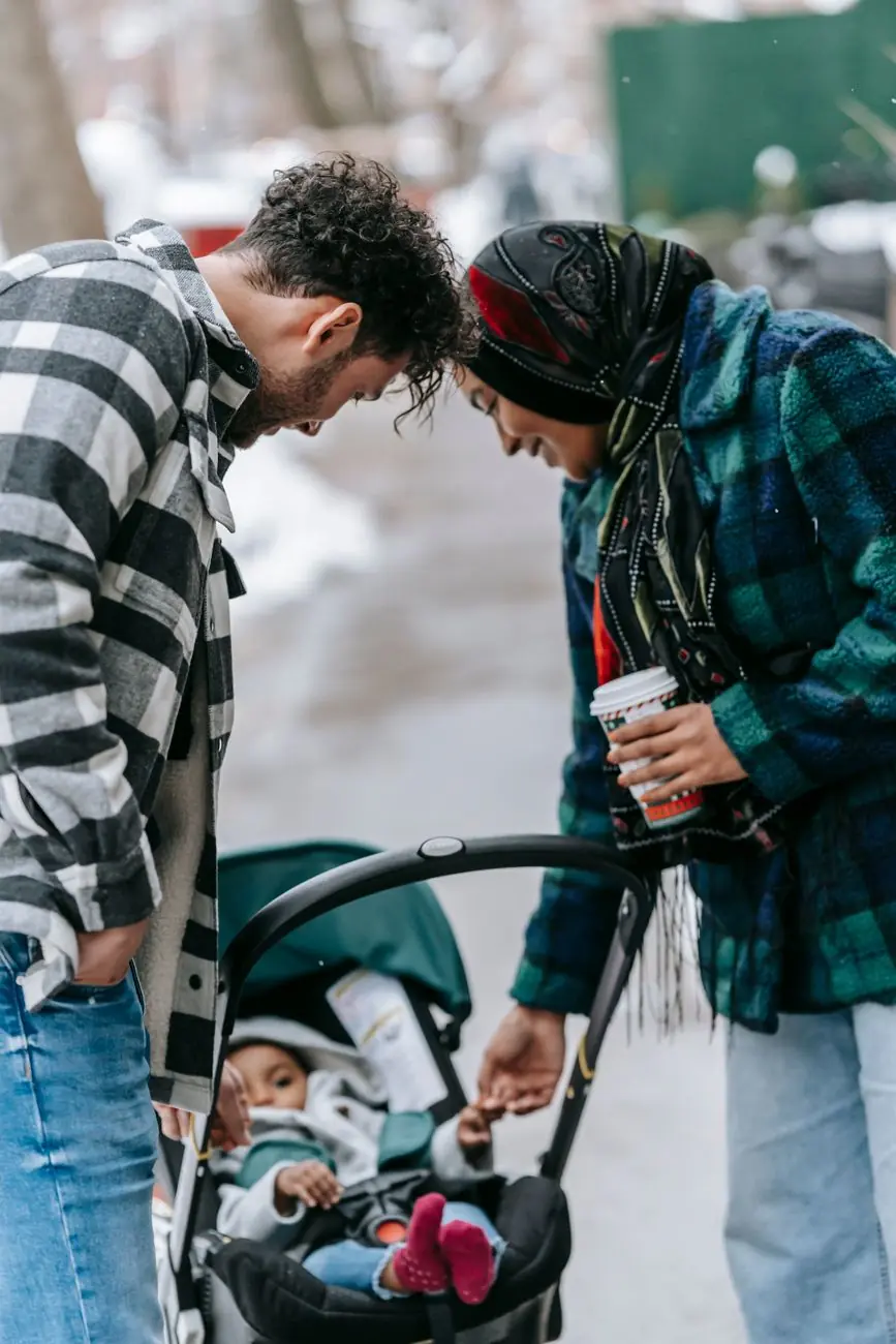 Two parents chatting over coffee beside a pram