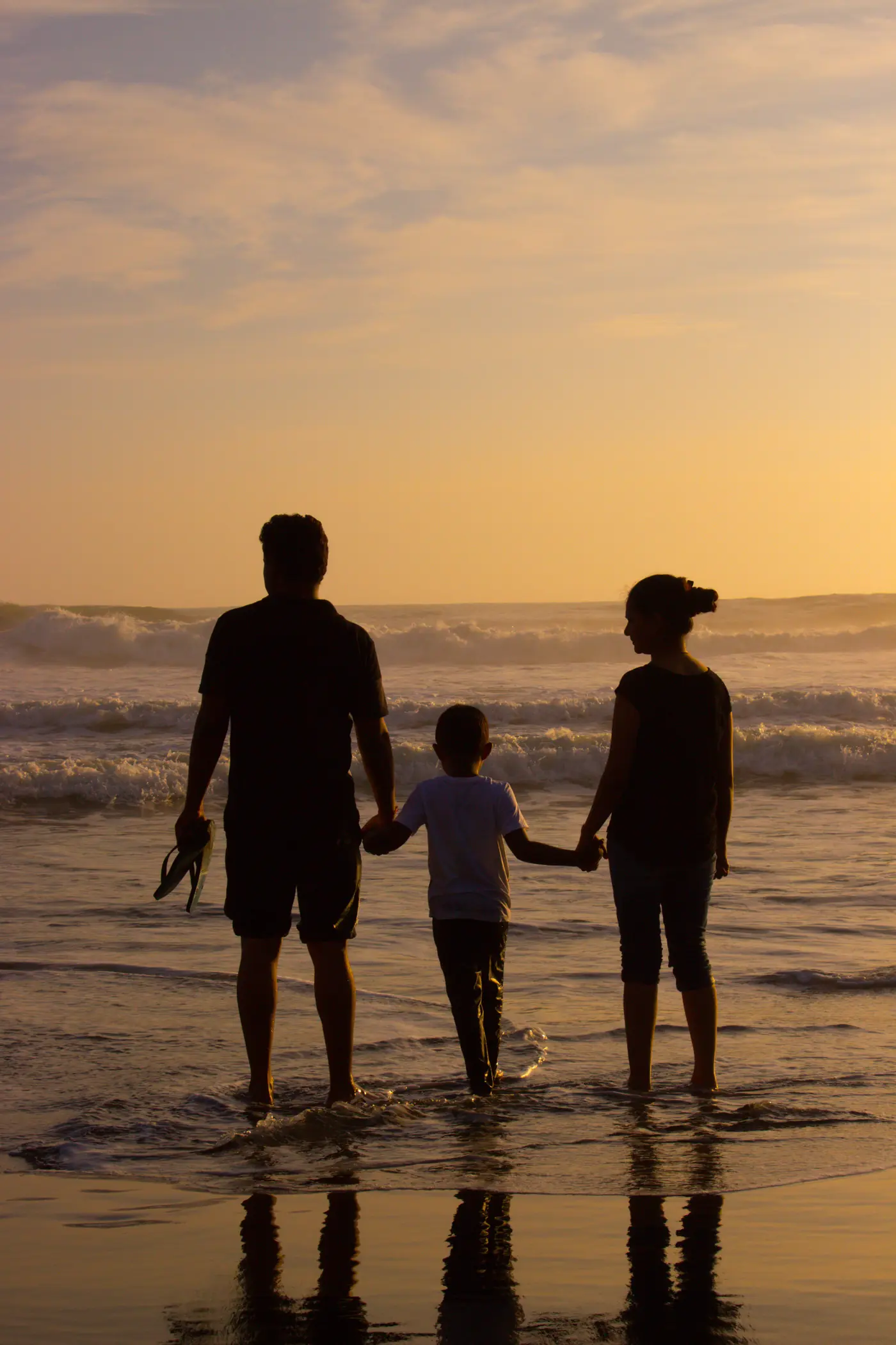 Parents walking together at sunset, hands joined