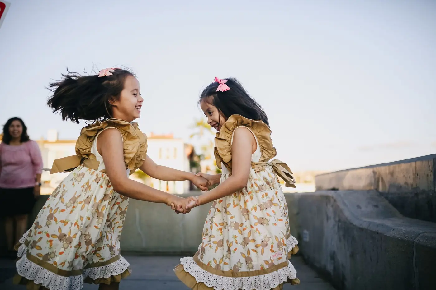 Twin girls laughing together in the sunshine