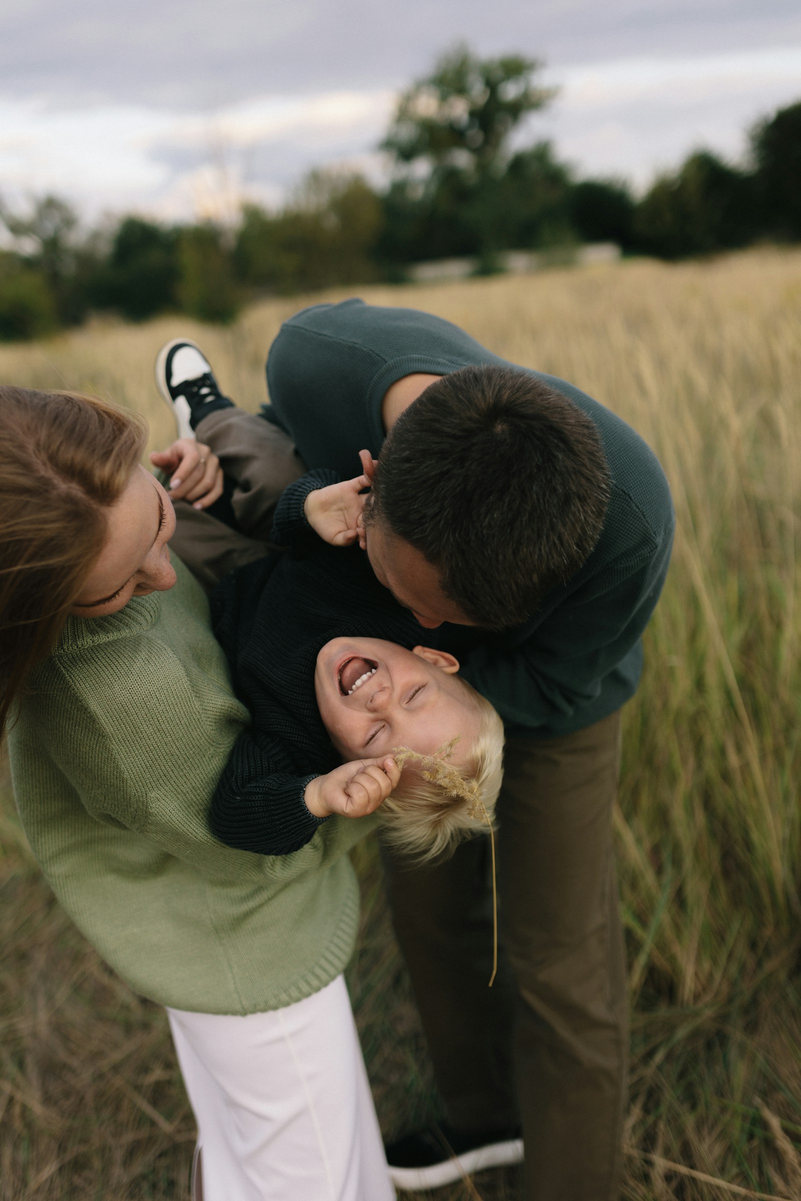 A family playing together outdoors in a grassy field